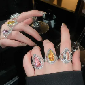Close-up detail of luxury teardrop rings with sparkling pink, yellow, and clear stones