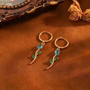 Detailed macro view of elegant tulip earrings with blue crystals and green leaves