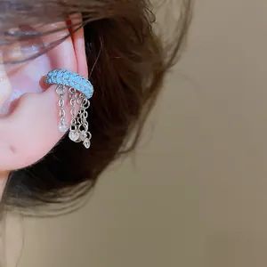 Close-up view of a blue tassel ear cuff with sparkling zircon pendants on the ear