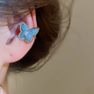 Exquisite macro detail of a blue butterfly zircon ear cuff earring worn on the ear