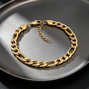 Détail d'un bracelet gourmette Figaro en acier inoxydable doré sur une assiette grise