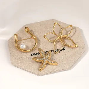 Elegant gold-plated stainless steel brooch set featuring starfish and flower designs.