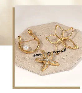 Macro view of gold-plated stainless steel starfish and flower brooches with pearl detail