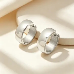 Close-up of polished silver wide stainless steel hoop earrings with a secure latch