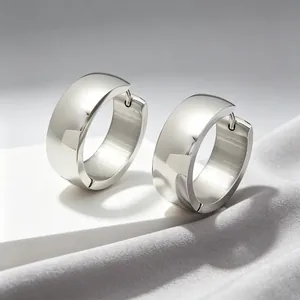 Close-up view of polished stainless steel silver hoop earrings for men and women