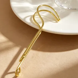 Gros plan d'un bijou de lèvre doré avec un design minimaliste en fil métallique