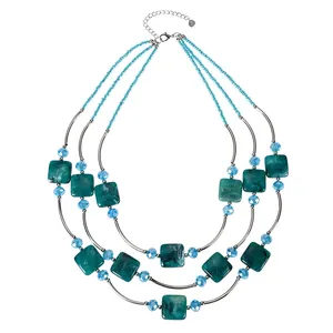 Detail view of a 3-layer teal square resin bead necklace with blue accents