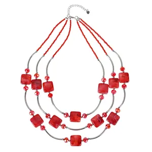 Detailed view of triple-layered necklace with red square beads and silver tubes