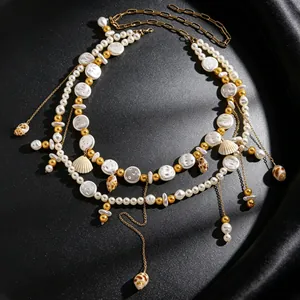 Macro view of resort style shell and pearl waist chain with golden tassel pendants