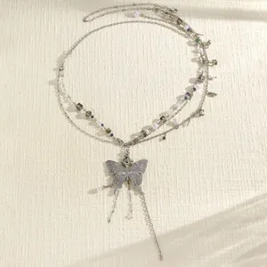 Detail showing the intricate silver multi-layer waist chain and butterfly pendant.
