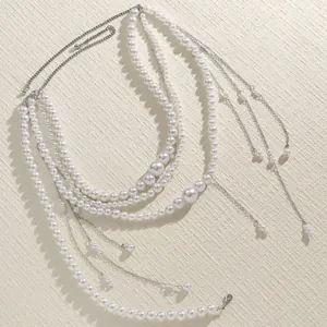 Detailed view of elegant multi-layered pearl waist chain with silver chain tassels