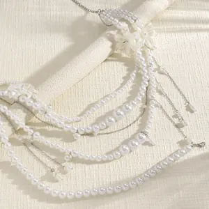 Close-up detail of a multi-layered white pearl waist chain with shell charms and fringe
