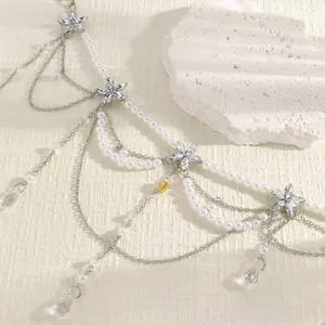 Macro close-up view of a layered pearl waist chain with crystal flowers and pendants