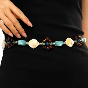 Detail shot of a bohemian waist chain with colorful wooden beads and marbled resin stones.