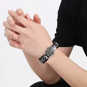Detailed view of men's wolf head medallion bracelet with black braided leather and silver chain