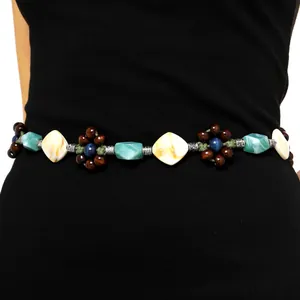 Detail view of boho waist chain with turquoise beads and wooden flowers on black dress