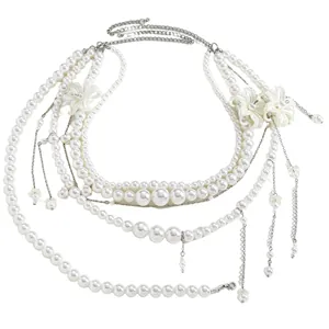 Detail view of multi-layer pearl waist chain with white flower charms and silver chains