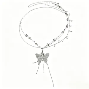 Detail showing a silver butterfly pendant on a multi-layer pearl waist chain
