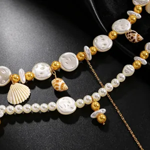 Detailed macro view of resort style pearl waist chain with shell and conch charms