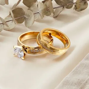 Close-up of gold-plated stainless steel couple rings with intricate stone settings