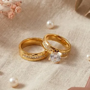 Detailed close-up of gold stainless steel couple rings with diamonds on textured linen.
