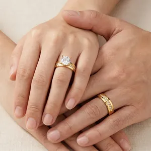 Close-up detail of textured gold-plated stainless steel wedding rings on interlaced hands
