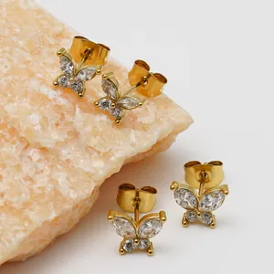 Close-up detail of gold-plated butterfly stud earrings with sparkling zircon stones.