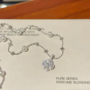 Close-up of silver flower pendant necklace with white pearls and sparkling zircons