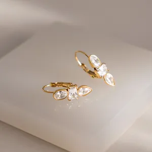 Primo piano di orecchini in acciaio inossidabile placcato oro 18K con zirconi rettangolari e pera