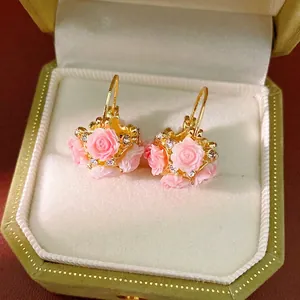 Elegant gold flower basket hoop earrings with pink resin roses and sparkling rhinestones