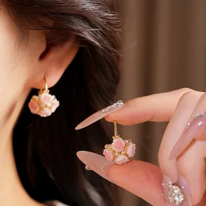 Elegant gold basket earrings with pink resin roses and sparkling crystals detail
