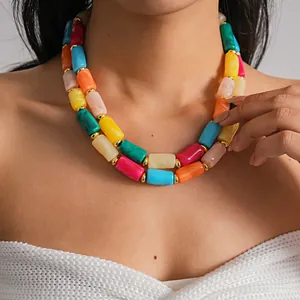 Dettaglio delle perle cilindriche in acrilico marmorizzato su una collana a strati
