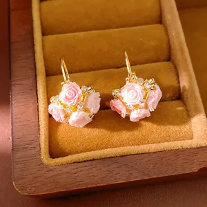 Close-up of pink resin rose flower basket earrings with sparkling rhinestone accents