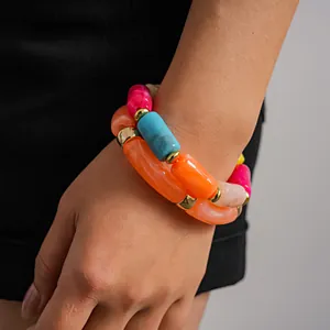 Primo piano di braccialetti colorati in acrilico marmorizzato su un polso