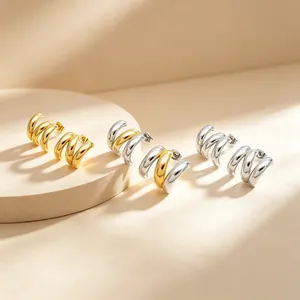 Détail de trois paires de boucles d'oreilles en C en acier inoxydable or et argent.
