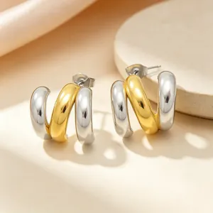 Vue détaillée des boucles d'oreilles créoles en acier inoxydable bicolore or et argent.