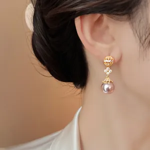 Detail view of elegant French hollow pearl earrings with diamond accents