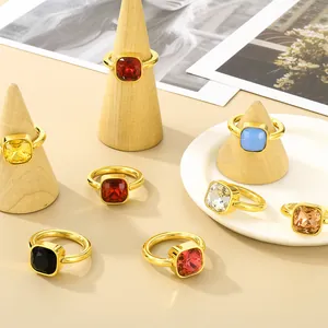 Modische Ringe aus Titanstahl mit bunten quadratischen Zirkonsteinen auf Holzständern