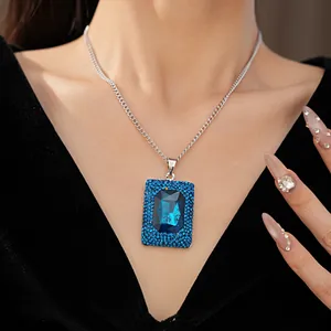 Detail of an elegant geometric square blue crystal pendant on a silver chain necklace
