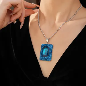 Detailed view of elegant square blue crystal pendant necklace worn by a model