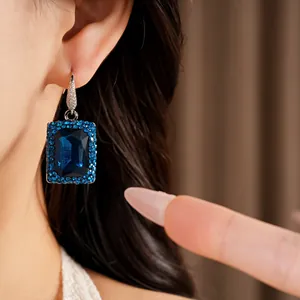 Close-up detail of an elegant geometric square blue sapphire earring with micro-diamond setting