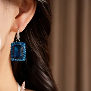 Detailed macro view of elegant rectangular blue gemstone earrings with crystals