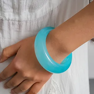 Detailed view of a light blue minimalist resin bangle with a swirled translucent texture.