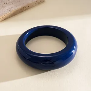 Detailed close-up of a dark blue glossy resin bangle with retro geometric round design