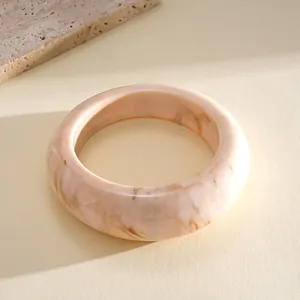 Detail of a vintage resin marble bangle with pink and brown swirled pattern design.