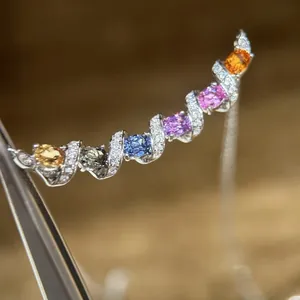 Gros plan d'un collier arc-en-ciel élégant avec des pierres ovales de couleur et diamants.