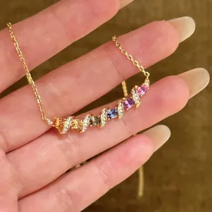 Vue macro d'un collier en pierres précieuses arc-en-ciel dorées avec des accents de diamants
