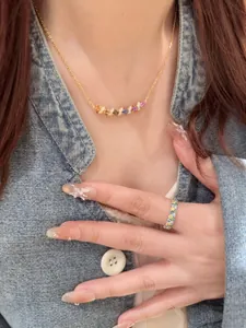 Gros plan détaillé d'un élégant collier en pierres arc-en-ciel et d'une bague assortie