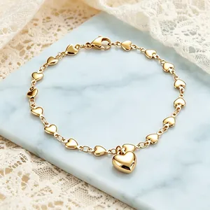 Nahaufnahme eines goldenen Armbands mit Herzgliedern und einem großen Herzanhänger.
