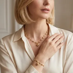 Detailansicht eines eleganten Sets aus Goldhalskette und Armband mit Herzanhänger